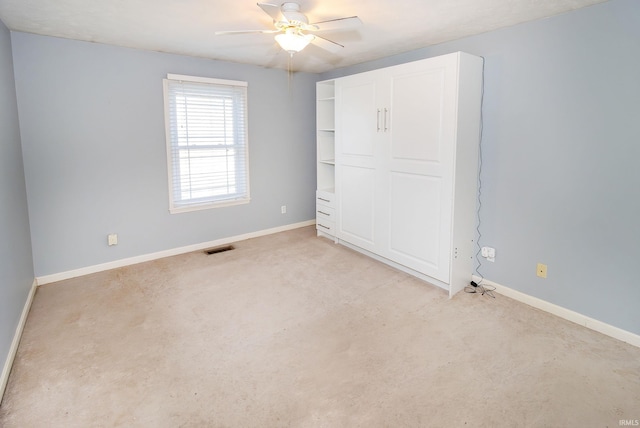 unfurnished bedroom featuring light carpet and ceiling fan