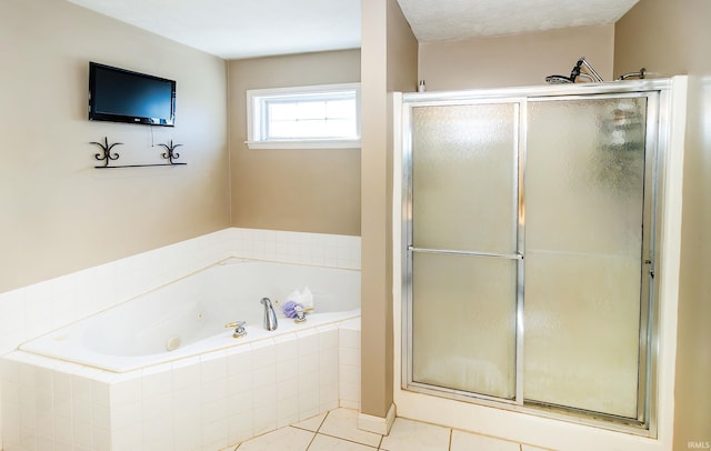 bathroom with a textured ceiling, separate shower and tub, and tile patterned flooring