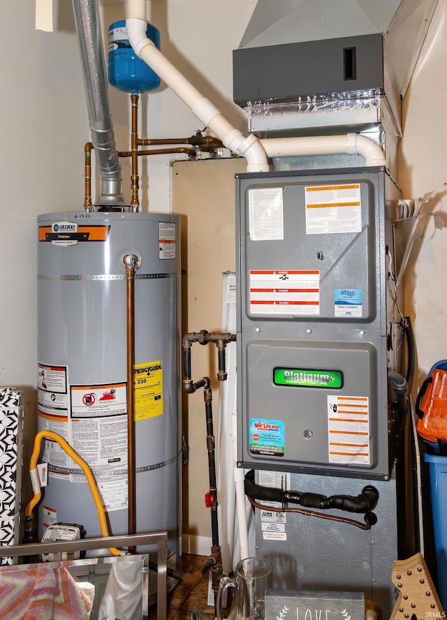 utility room featuring heating unit and gas water heater