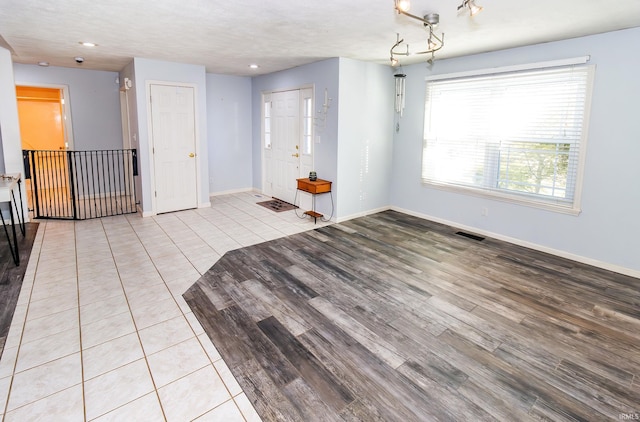 spare room with a textured ceiling and light hardwood / wood-style floors