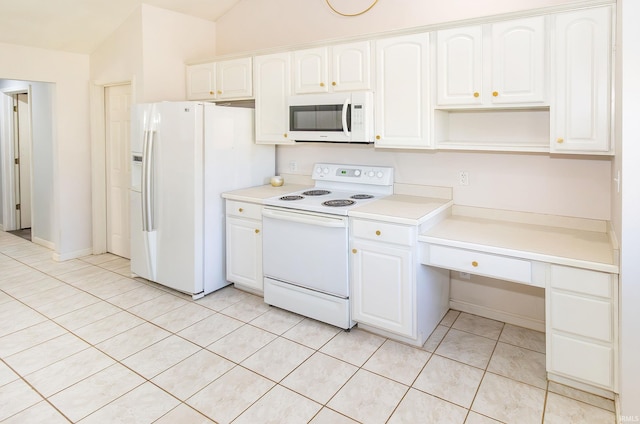 kitchen with white appliances, light tile patterned flooring, vaulted ceiling, and white cabinets