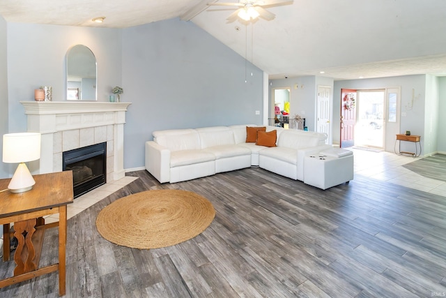 living room with vaulted ceiling with beams, hardwood / wood-style floors, a fireplace, and ceiling fan