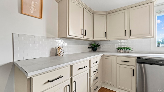 kitchen with decorative backsplash, dishwasher, light hardwood / wood-style floors, and cream cabinetry