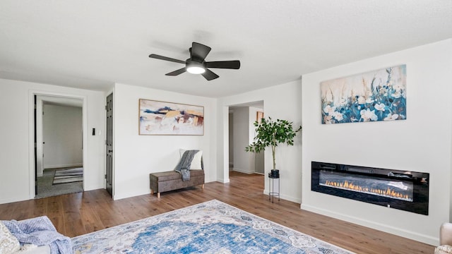 living area featuring wood-type flooring and ceiling fan