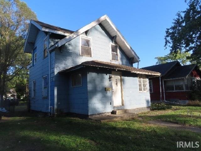 back of house with a lawn