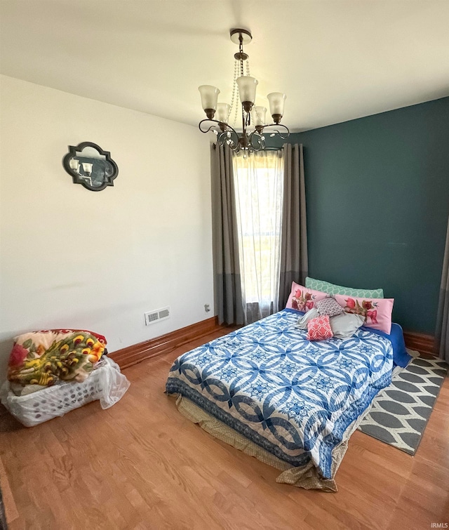 bedroom featuring a notable chandelier and wood-type flooring