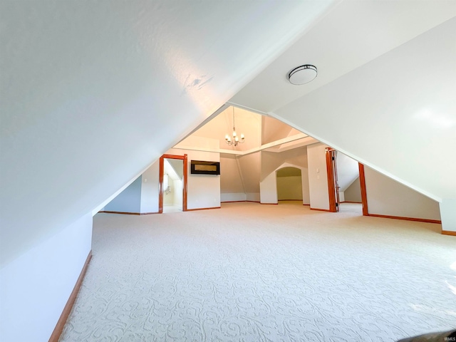 additional living space featuring lofted ceiling, carpet flooring, and a chandelier