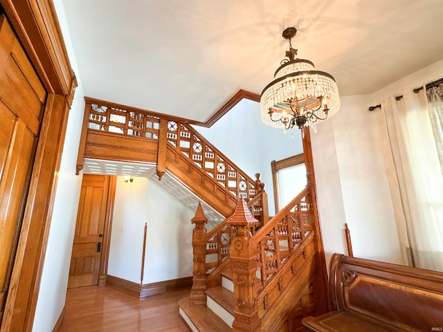 stairs featuring an inviting chandelier and hardwood / wood-style flooring