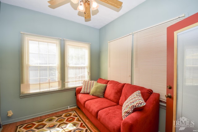 living room with wood-type flooring and ceiling fan