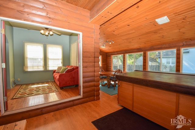 interior space with wooden ceiling, light hardwood / wood-style floors, log walls, and a healthy amount of sunlight