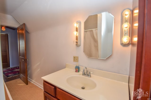 bathroom with vanity and lofted ceiling