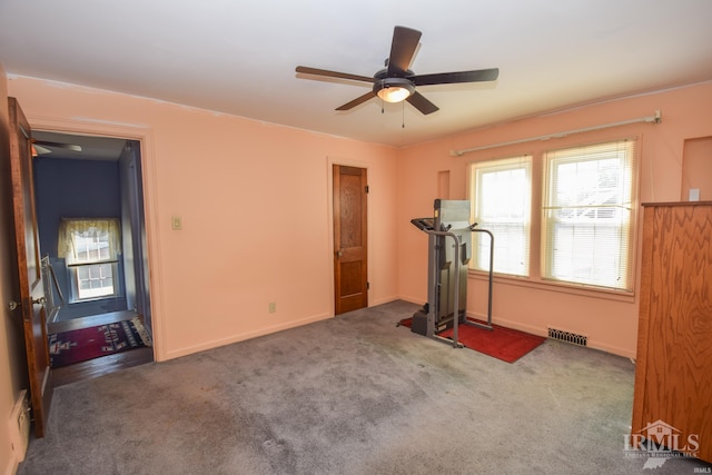 workout area featuring ceiling fan and dark carpet