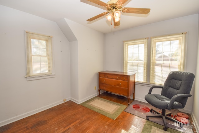 living area with a wealth of natural light, ceiling fan, and hardwood / wood-style flooring