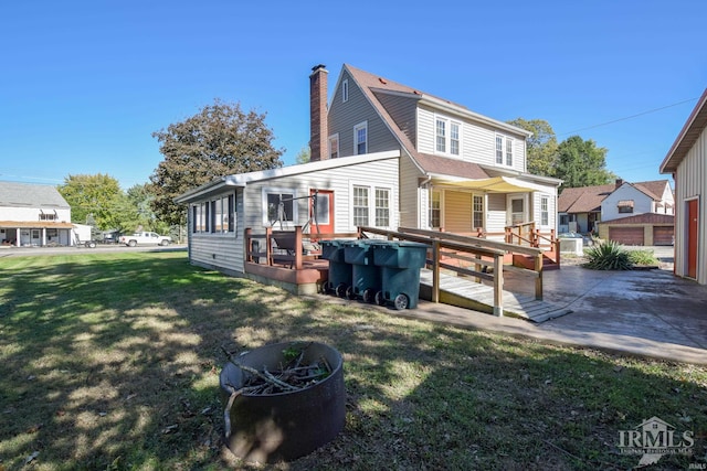 back of house with a garage, a wooden deck, and a lawn