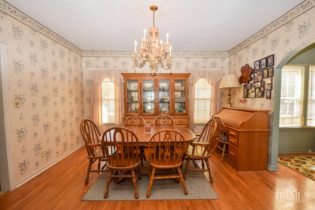 dining space featuring light hardwood / wood-style flooring, plenty of natural light, and an inviting chandelier