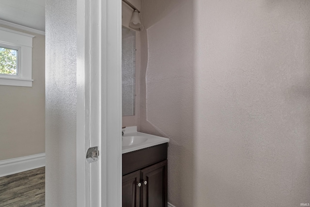 bathroom featuring hardwood / wood-style flooring, vanity, and crown molding