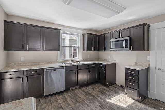 kitchen with dark brown cabinets, sink, dark wood-type flooring, and stainless steel appliances