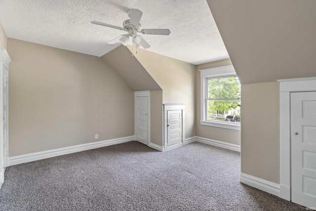 additional living space with ceiling fan, a textured ceiling, lofted ceiling, and carpet