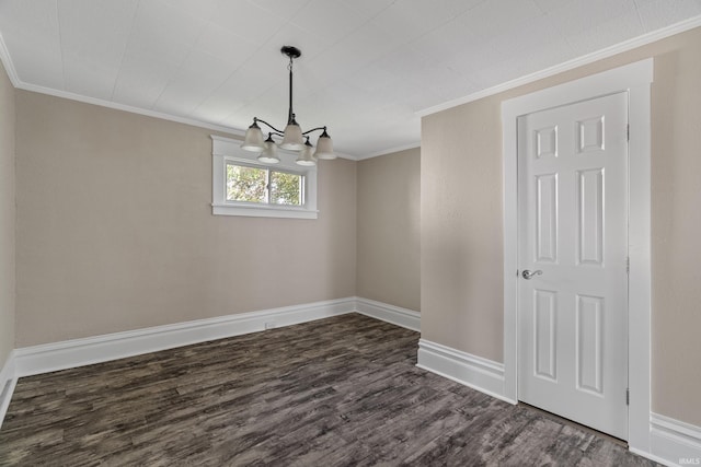 empty room featuring ornamental molding, a chandelier, and dark wood-type flooring