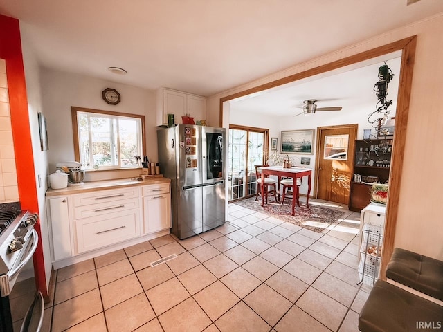 kitchen with white cabinets, ceiling fan, appliances with stainless steel finishes, and light tile patterned floors