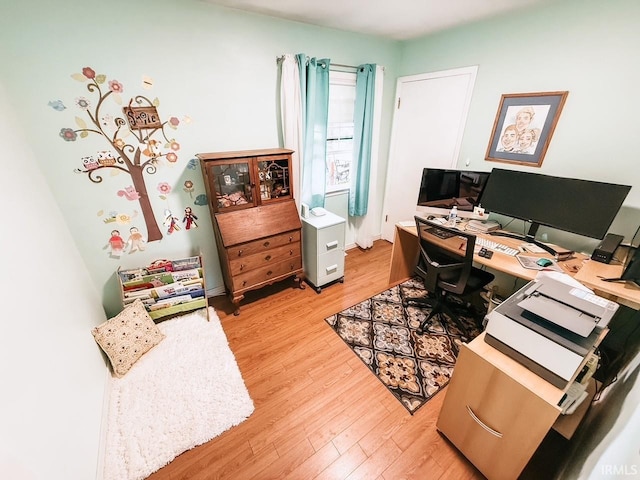 home office with light hardwood / wood-style flooring