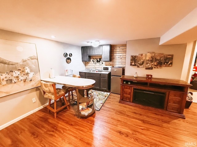 kitchen featuring light hardwood / wood-style flooring, backsplash, and stainless steel refrigerator