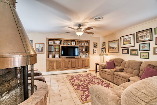 living room with ceiling fan, light tile patterned floors, crown molding, built in features, and a baseboard radiator