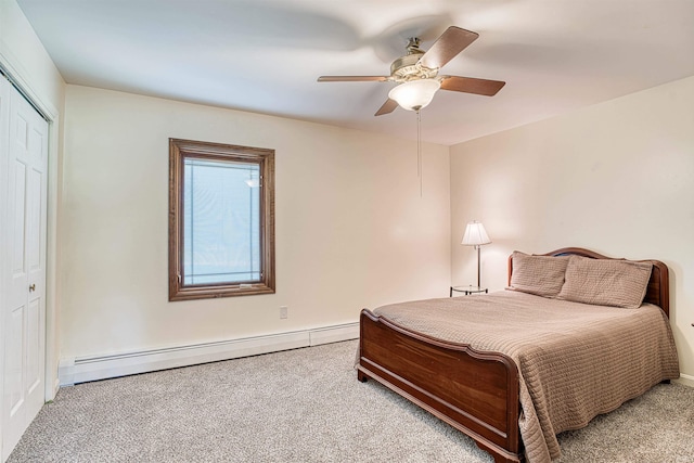 carpeted bedroom with baseboard heating, ceiling fan, and a closet