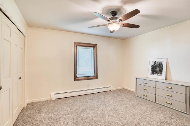 unfurnished bedroom featuring a baseboard radiator, ceiling fan, light colored carpet, and a closet