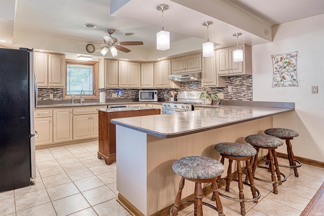 kitchen with kitchen peninsula, a breakfast bar area, light tile patterned floors, and stainless steel appliances