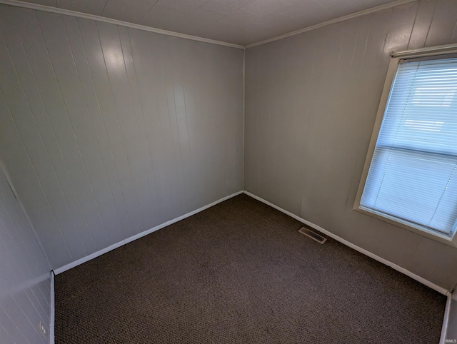 empty room with ornamental molding and carpet flooring