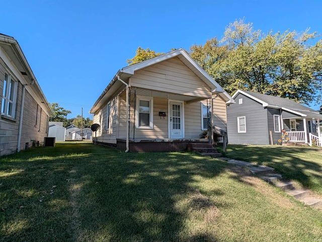 bungalow-style house with a front lawn and central AC unit