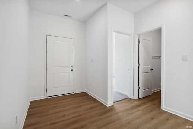 corridor with hardwood / wood-style floors