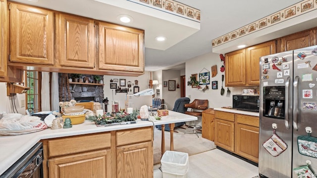 kitchen with dishwashing machine, a stone fireplace, and stainless steel fridge with ice dispenser