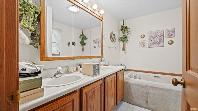 bathroom with vanity, a textured ceiling, and a bathtub