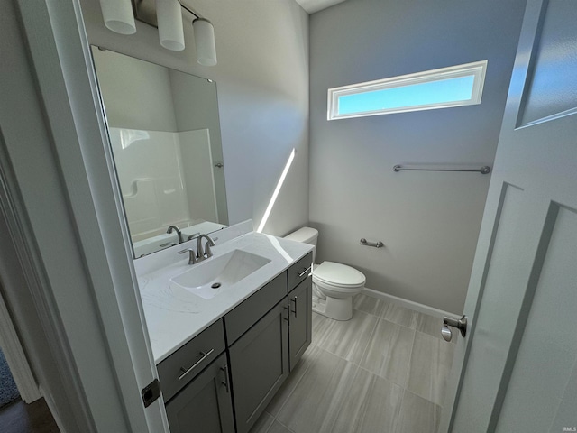 bathroom with walk in shower, vanity, and toilet