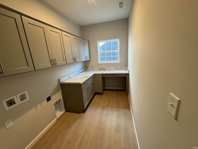 laundry area with hookup for a washing machine, cabinets, light hardwood / wood-style flooring, and hookup for an electric dryer