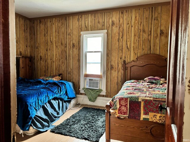 bedroom featuring wood-type flooring, cooling unit, and wooden walls