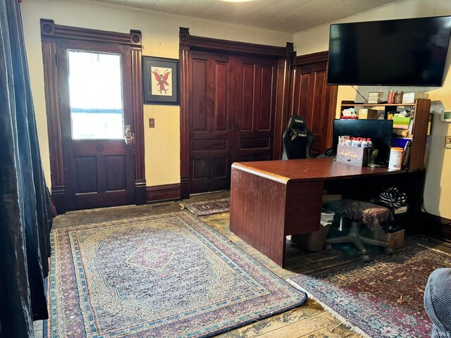 home office with wooden walls and hardwood / wood-style flooring