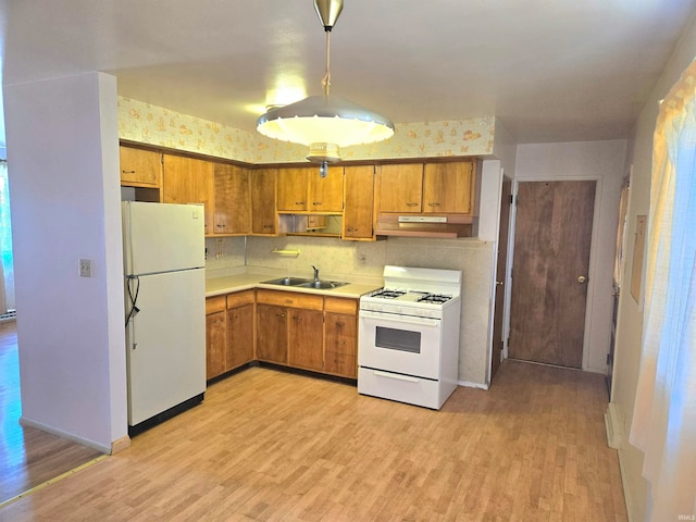 kitchen with decorative backsplash, light hardwood / wood-style floors, white appliances, decorative light fixtures, and sink