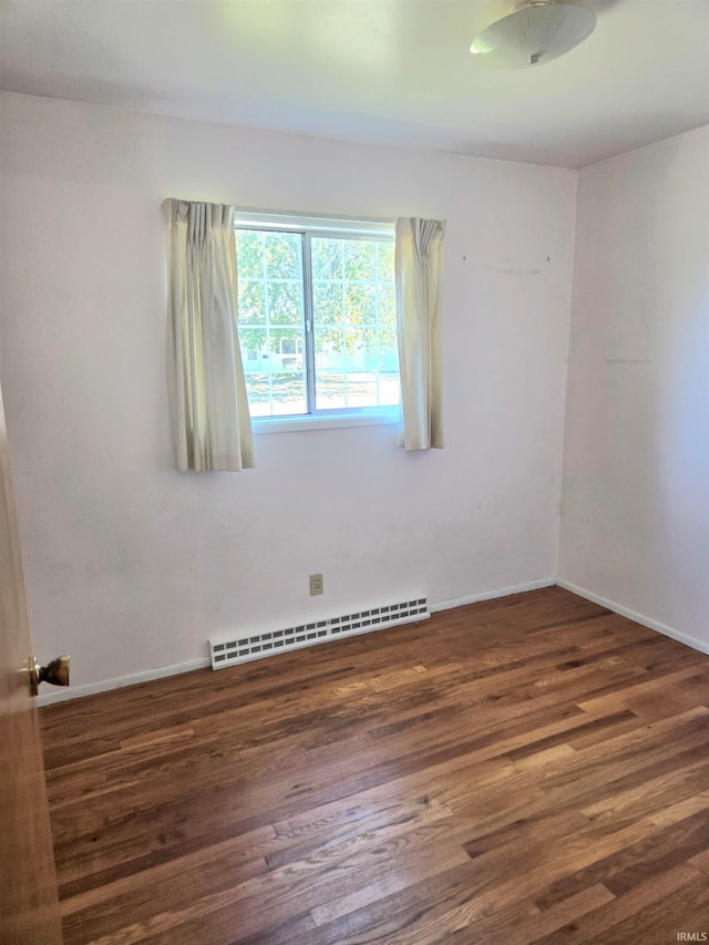 unfurnished room with dark hardwood / wood-style floors and a baseboard radiator