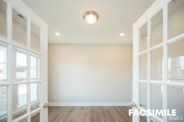 spare room with french doors and hardwood / wood-style floors