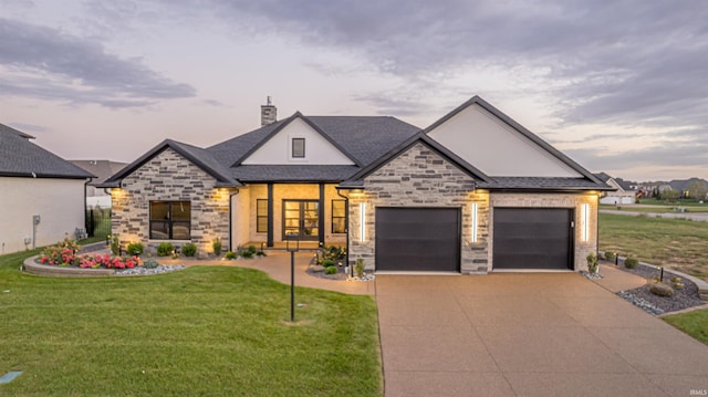 view of front of property featuring a garage and a lawn