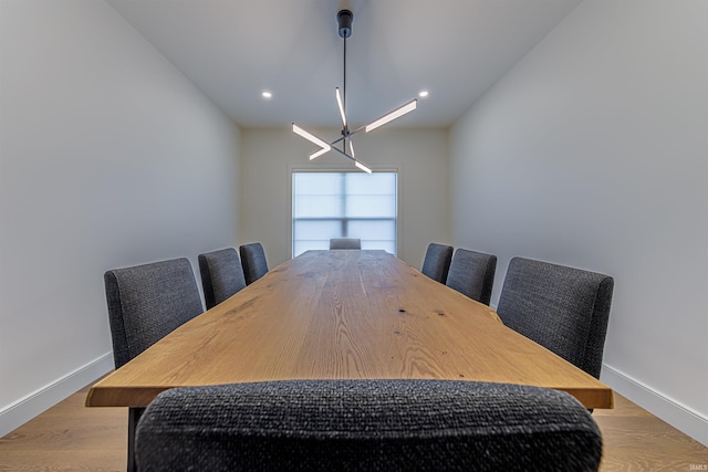 dining area featuring light hardwood / wood-style flooring and a chandelier