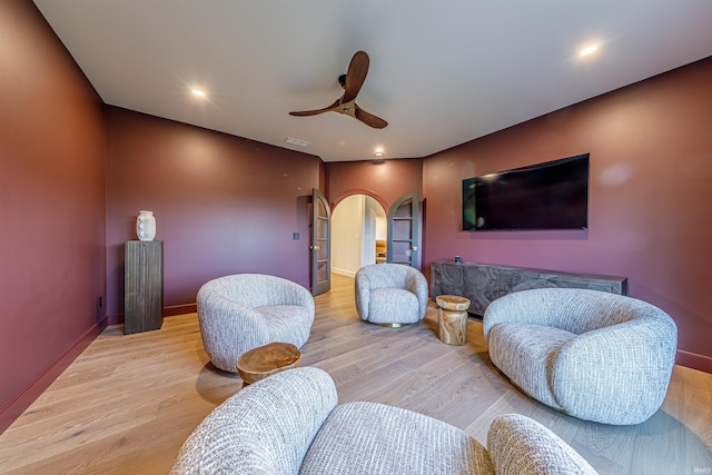 living room with light hardwood / wood-style flooring and ceiling fan