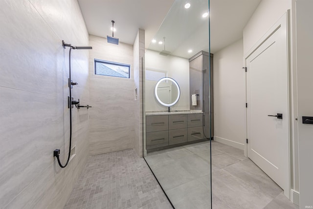 bathroom with vanity and a tile shower