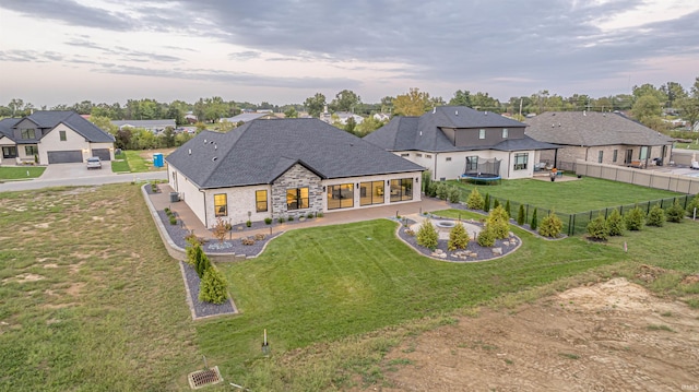 2065 Chadwick Dr, Newburgh, IN 47630 - back of house with a residential view, stone siding, a fenced backyard, a trampoline, and a patio