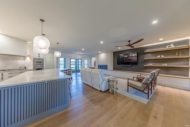 living room with french doors, light hardwood / wood-style flooring, and ceiling fan