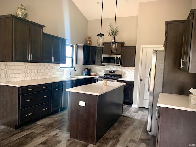 kitchen with a kitchen island, dark hardwood / wood-style flooring, pendant lighting, and stainless steel appliances