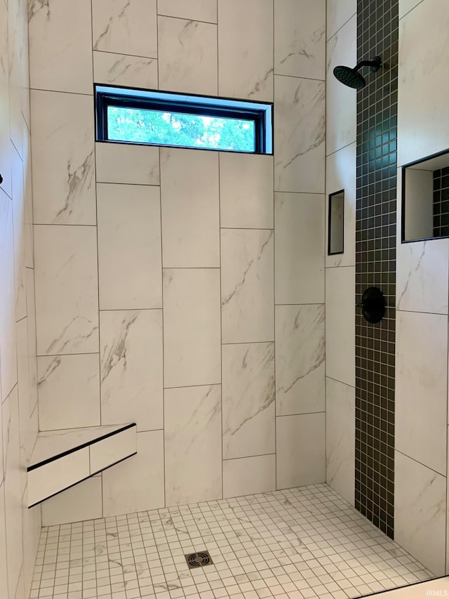 bathroom with tiled shower and plenty of natural light